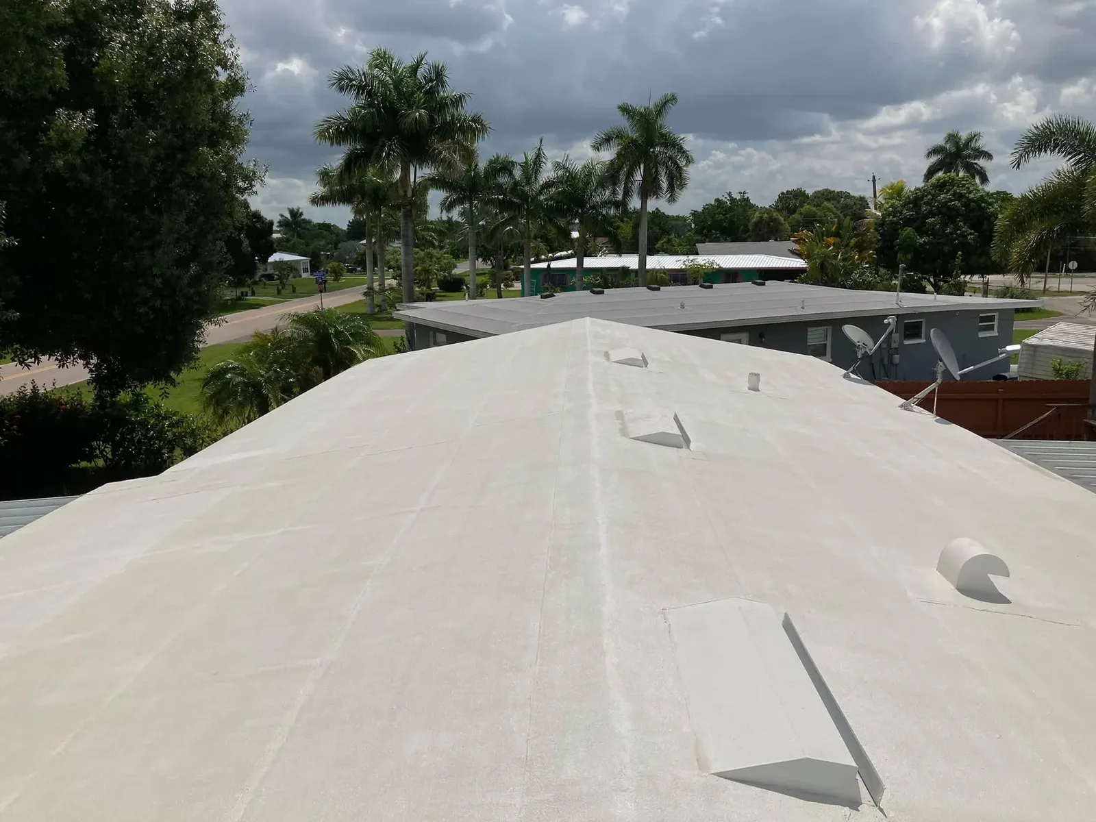 The same low slope roof after soft washing, the surface an even bright off white