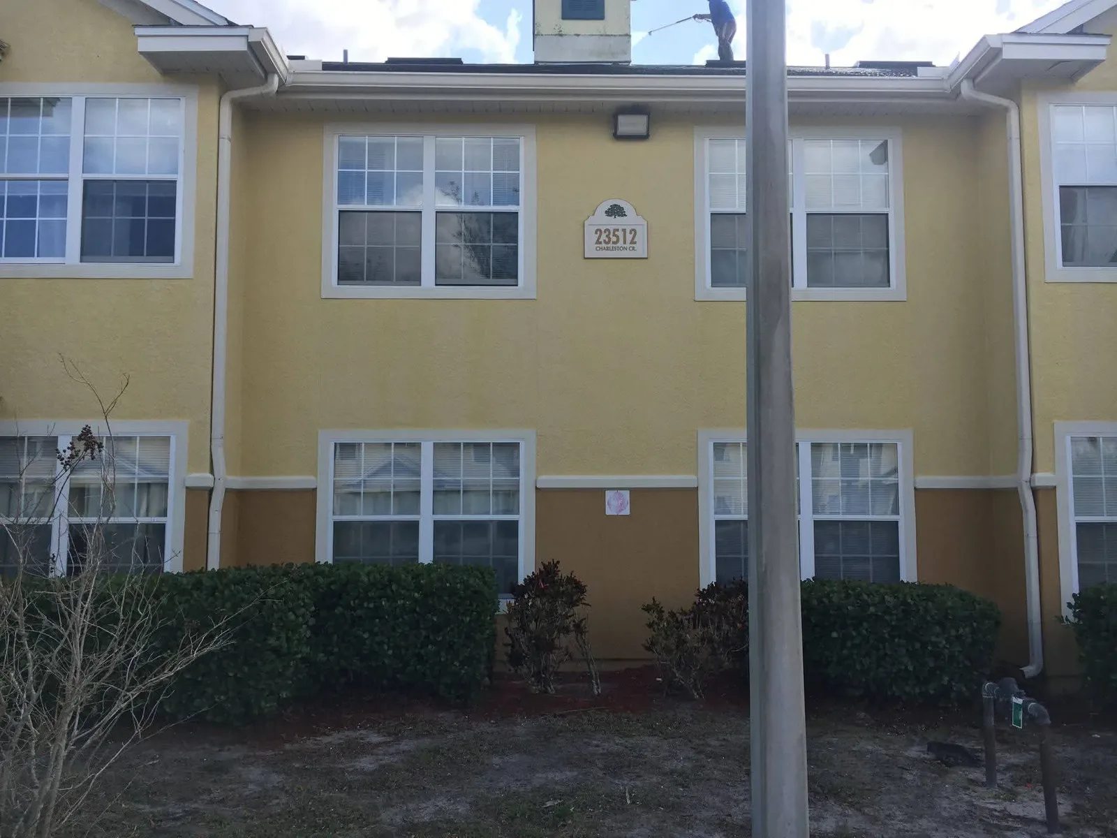 The same yellow stucco wall after washing, the colour even and the streaking gone