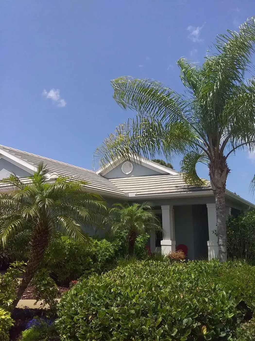 The same home after cleaning, tile roof and walls back to their original colour