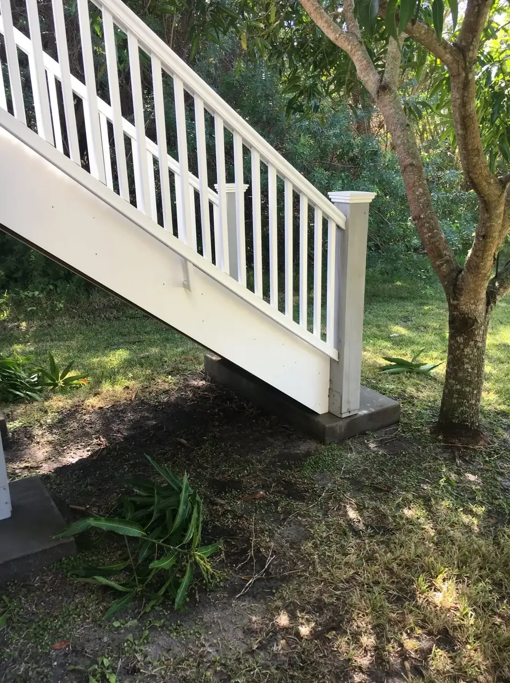 A clean white vinyl railing and balusters beside an exterior stair
